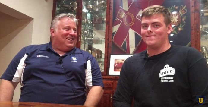 Liberty Player and coach sitting at a table for discussion